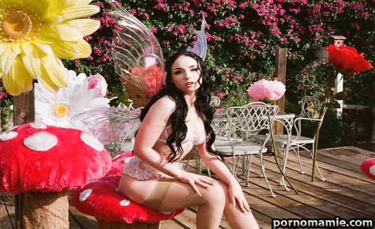 How to Explore Adult Nightly Connections Safely and Honestly Woman dressed as a fairy in lingerie sits on a giant red mushroom among oversized garden flowers in a sunny yard.